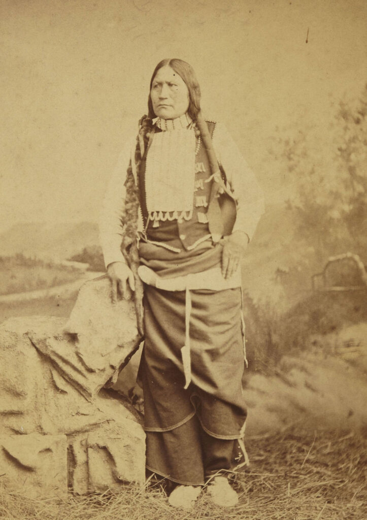 Černý uhel z kmene Arapaho s náprsenkou z porcelánových trubiček, tzv. bugle beads. Fotografie z toku 1882.