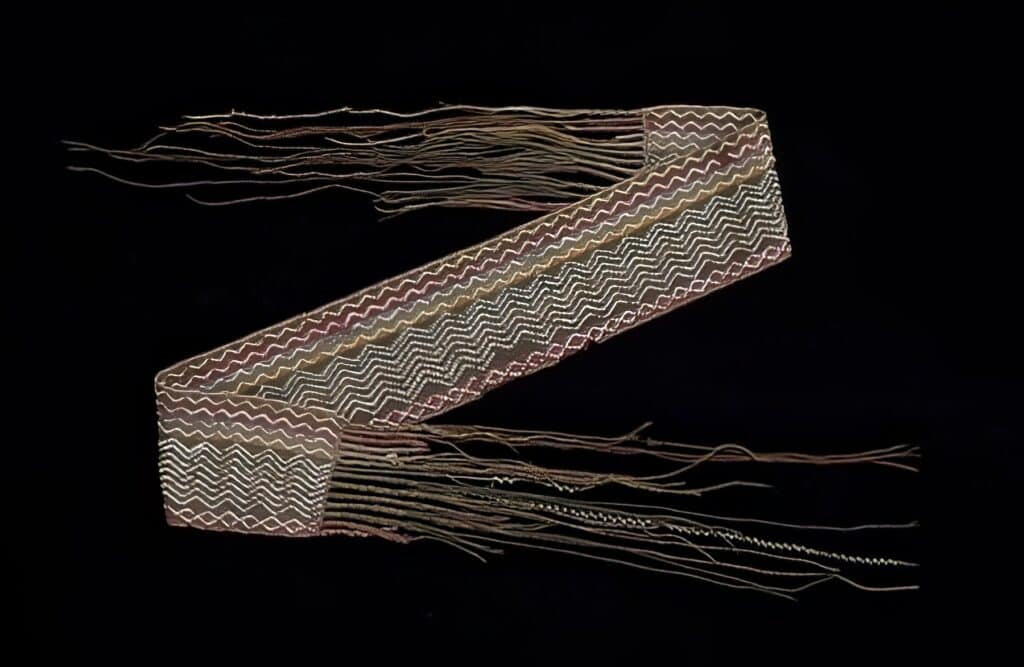 Sash vyrobená k nošení jako turban, jak napovídají její rozměry (11,4 x 57,5 cm, 160cm včetně třásní), Ojibwa, 1780, DIA