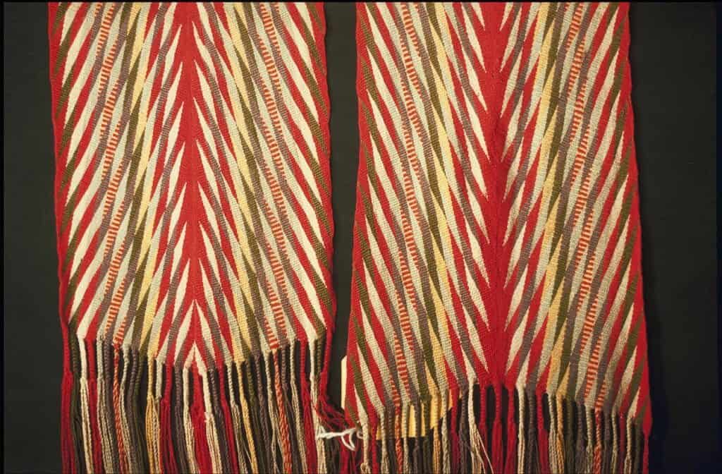 Detail sashe ceinture fléchée typu Assomption: rudé coeur ve středu a éclairs vybíjající diagonálně po stranách, Musée McCord.