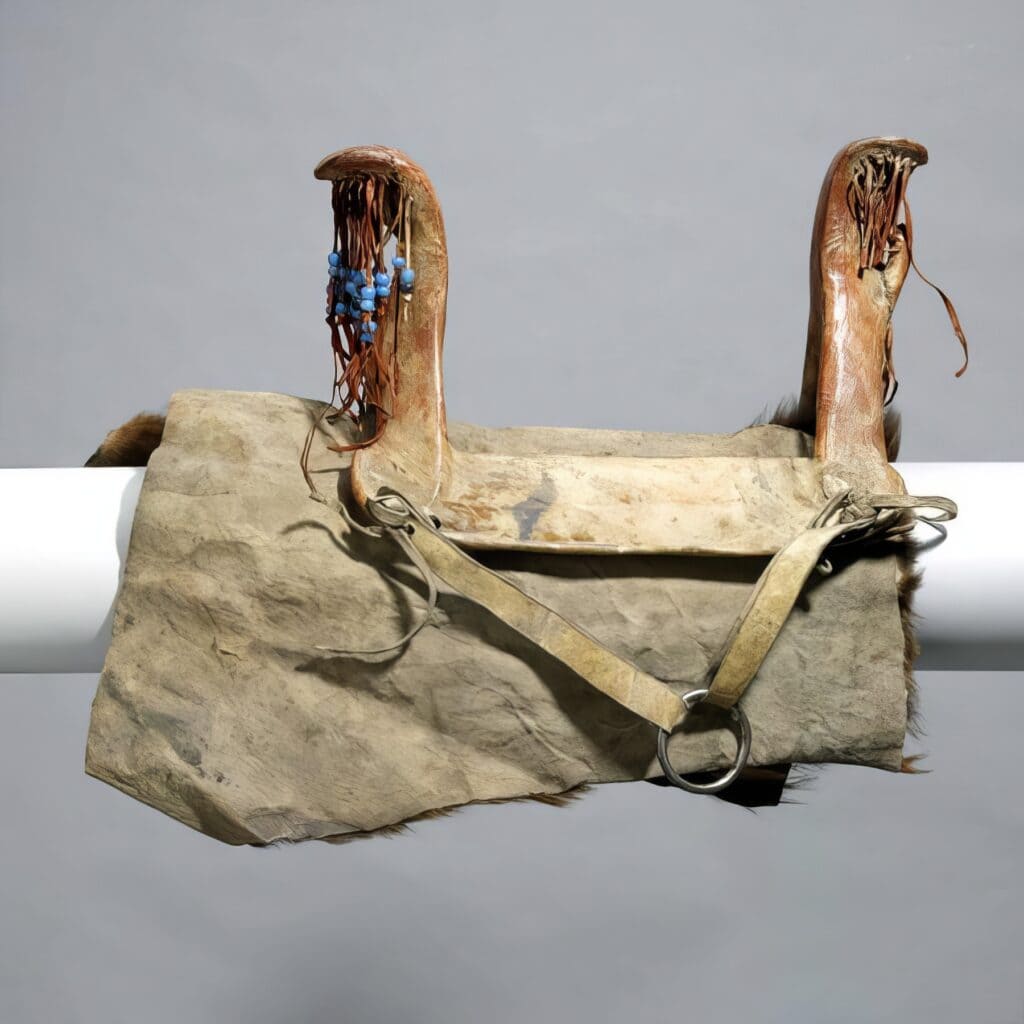 Ženské dřevěné sedlo vypodložené podsedlovou deku ve formě kusu bizoní kožešiny. Royal Ontario Museum.