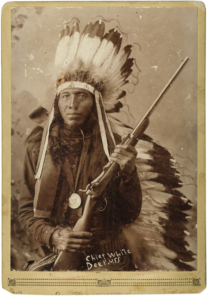 Bílý jelenec z kmene Lakotů-Sičanguů svírá v ruce karabinu Springfield Trapdoor 1873, dost možná kořistní z bitvy na Little Bighornu.
