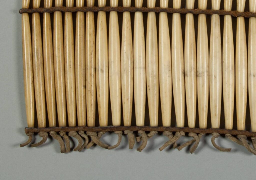 Detail proužků z komerční hověziny a uchycení kostic pomocí kožených řemínků zabezpečených uzlíkem.