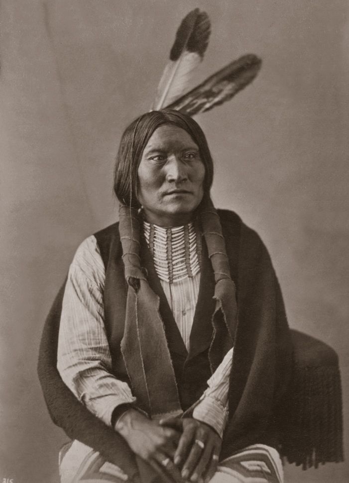 Špinavá tvář z kmene oglalských lakotů s kelnatkovou náprsenkou. Fotografie z toku 1872.