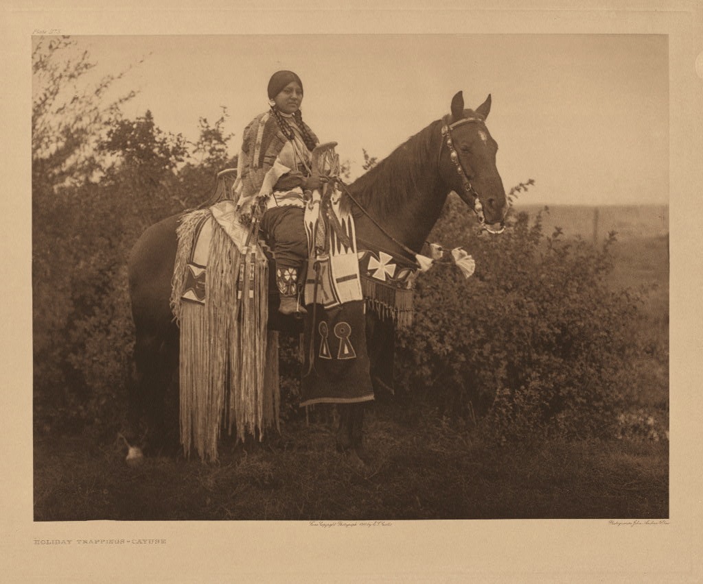 Indiánská žena z oblasti Plató na fotografii E.Curtise. Na zadní části sedla má zavěšený tubus s bohatým třásněním.