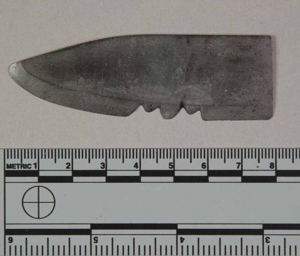 Nástroj na výrobu drážek vyrobený z čepele nože. Nástroj má dva drážkovací žlaby vedle sebe. Nástroj pochází od výrobce šípů kmene Kajova. NMNH.