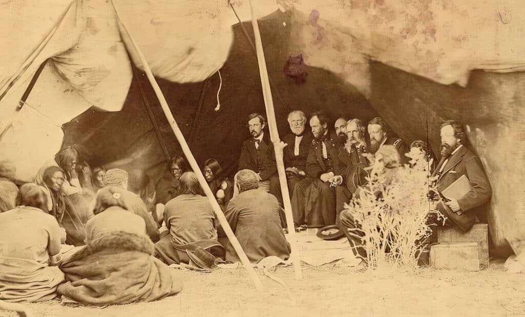 Jednání mezi indiánskými kmeny a zástupci vlády Spojených států. Na fotografii je v jednání smlouva z Fort Laeramie z roku 1868, která nahrazovala smlouvu z roku 1851.