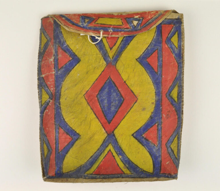 Plochá taška kmene Lakotů z 2. poloviny 19. století (rezervační období). Výrazné barvy a kombinace žluté, červené a modré jsou typické pro pozdější období, poslední čtvrtinu 19. století.