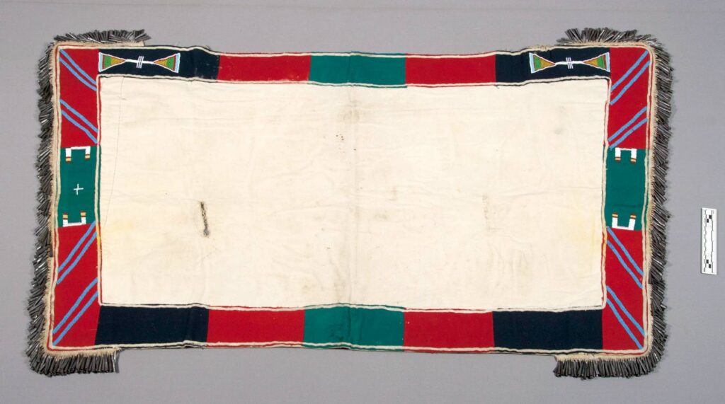 Podsedlová deka transmontánního původu. Vyrobená je z bavlněného nebo lněného plátna. NMNH.