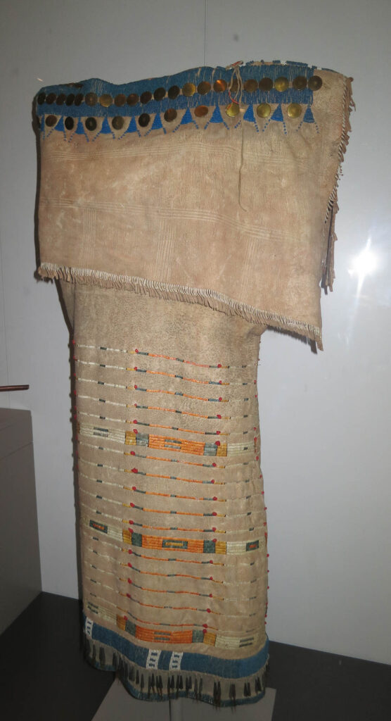 Šaty z přeložené kůže siouxského stylu, lakotské nebo šajenské, získal je Lewis s Clarkem, nyní Peabody Museum Harvard