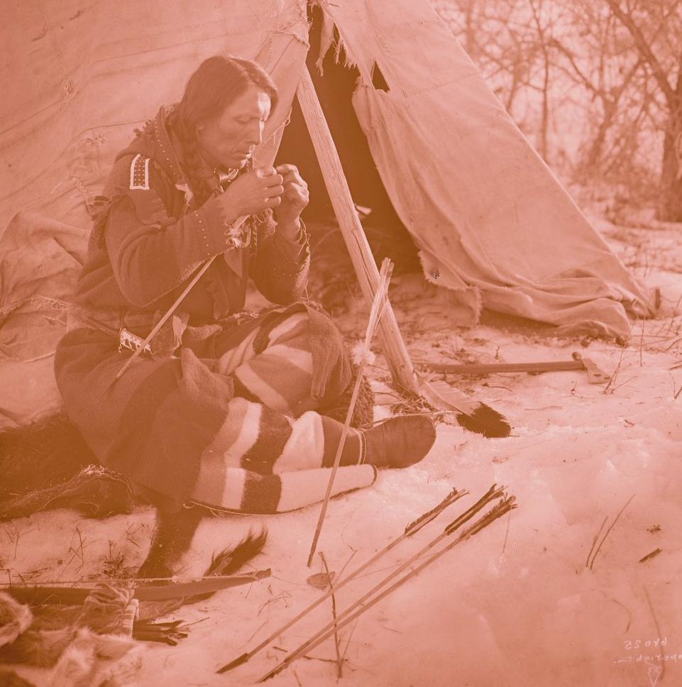 Indián z kmene Vran na fotografii Richarda Throssela vyrábí šípy.