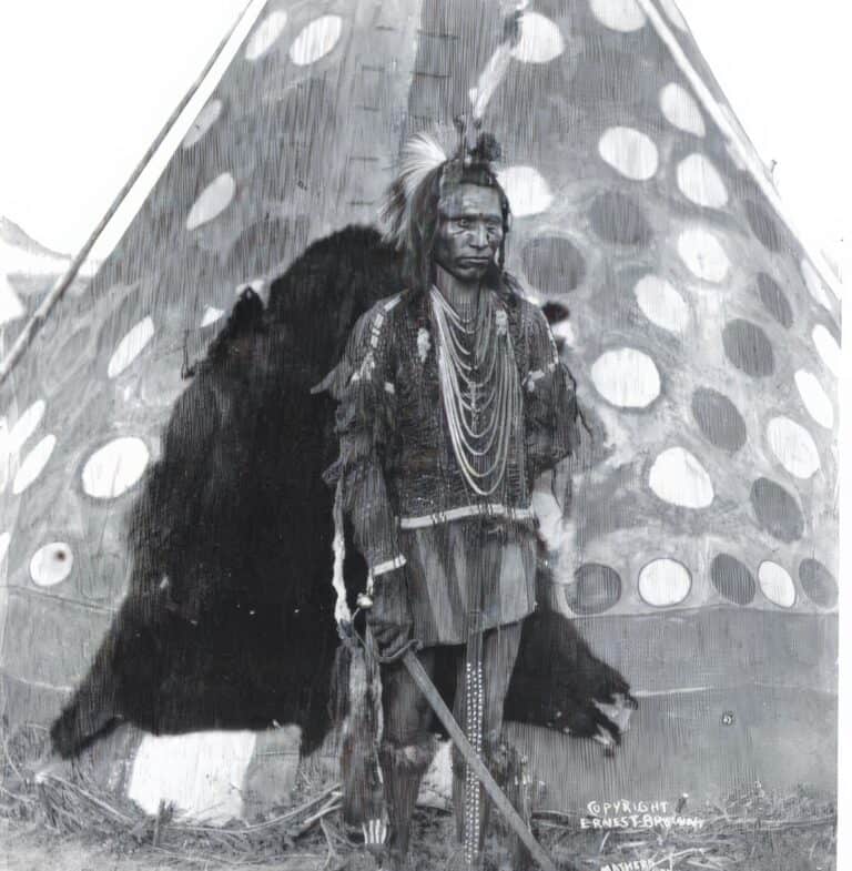 Dobová fotografie týpí kmene Černonožců s dveřmi vyrobenými z kožešiny medvěda Baribala.